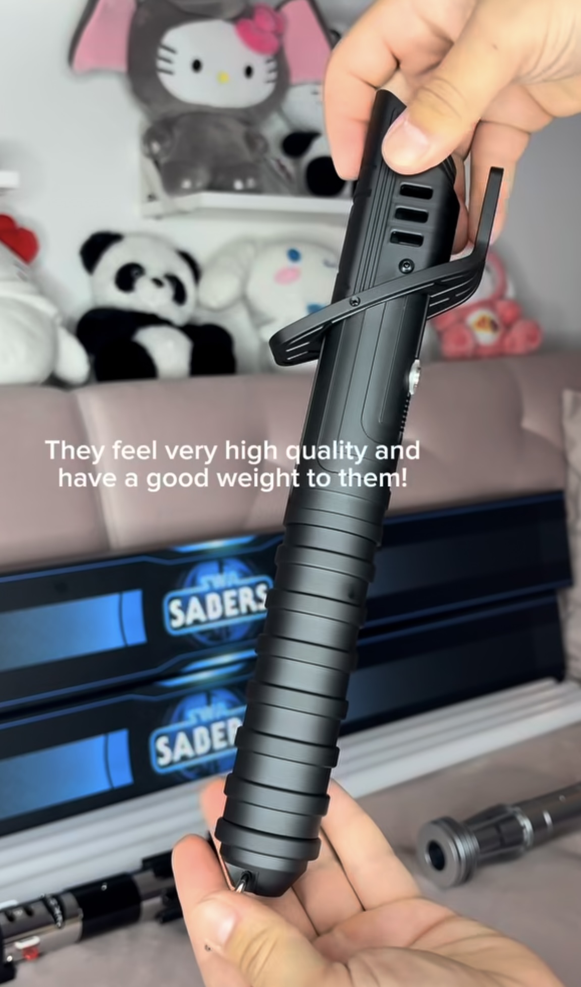 Close-up of a Darksaber hilt with two SWA Sabers boxes behind it